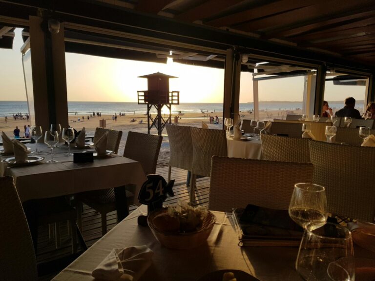 Enjoy a picturesque beachfront dining experience at sunset with ocean views and a cozy ambiance.