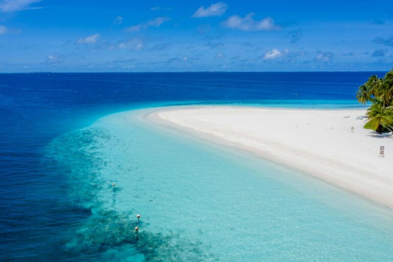 Aerial view of a serene tropical beach with turquoise waters in Guraidhoo, Maldives.