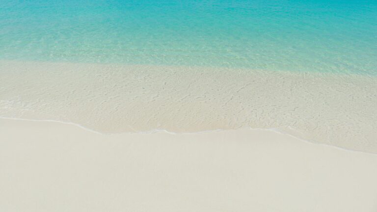 Tranquil view of clear blue sea and white sandy beach in the Maldives.