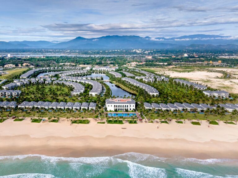 A stunning aerial view of a tropical resort with a beach and lush greenery in Vietnam.