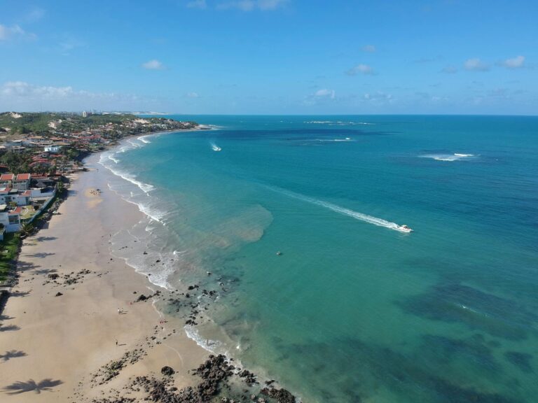 A stunning aerial view of a pristine beach in Natal, Rio Grande do Norte, Brazil, showcasing clear blue waters.