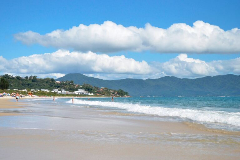 Beautiful tropical beach with mountains and white clouds, perfect for a summer getaway.