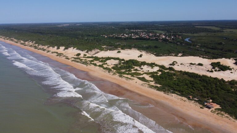Stunning aerial view of Conceição da Barra beach with lush greenery and clear waters in Brazil.