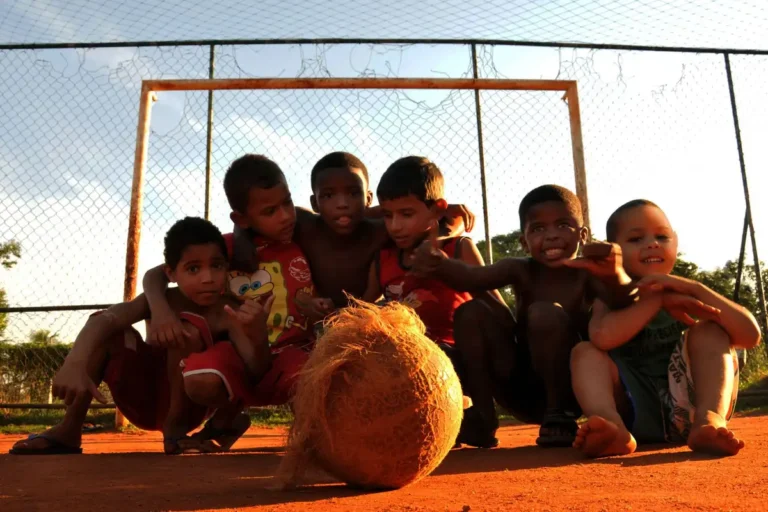Group of kids enjoying a lively game of soccer in a Rio de Janeiro neighborhood.