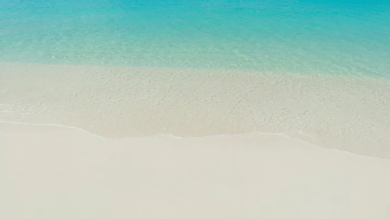 Tranquil view of clear blue sea and white sandy beach in the Maldives.