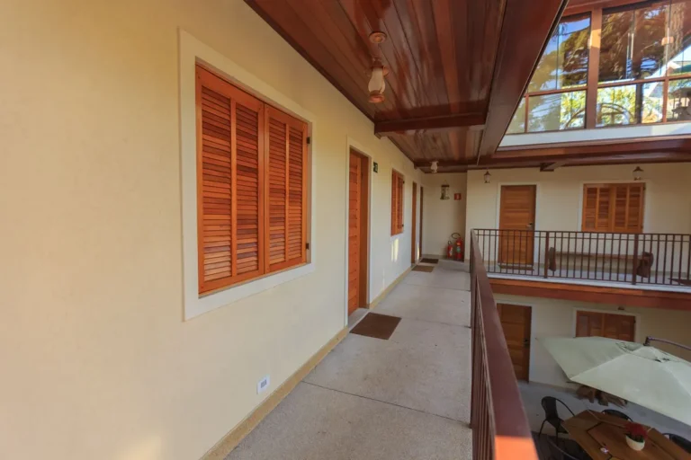 Spacious hotel courtyard featuring wooden doors, windows, and minimalist design.