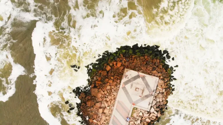 A stunning aerial shot capturing a rocky pier surrounded by ocean waves in Rio de Janeiro, Brazil.
