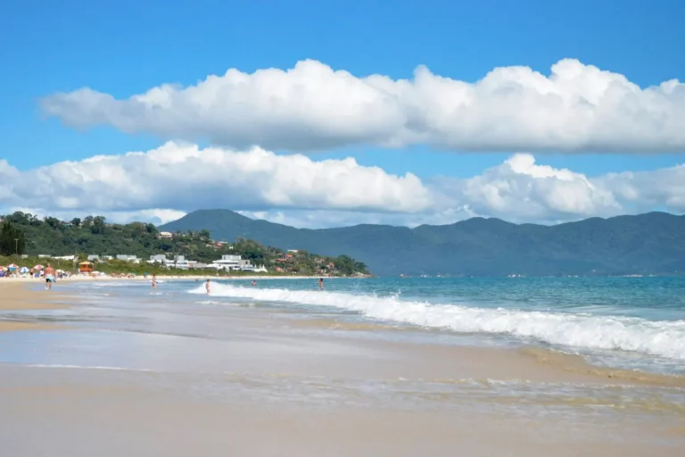 Beautiful tropical beach with mountains and white clouds, perfect for a summer getaway.